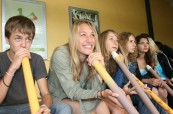 Studenti angličtiny, kteří si zkouší hru na tradiční australský hudební nástroj Didgeridoo, Lexis Noosa Heads, Austrálie